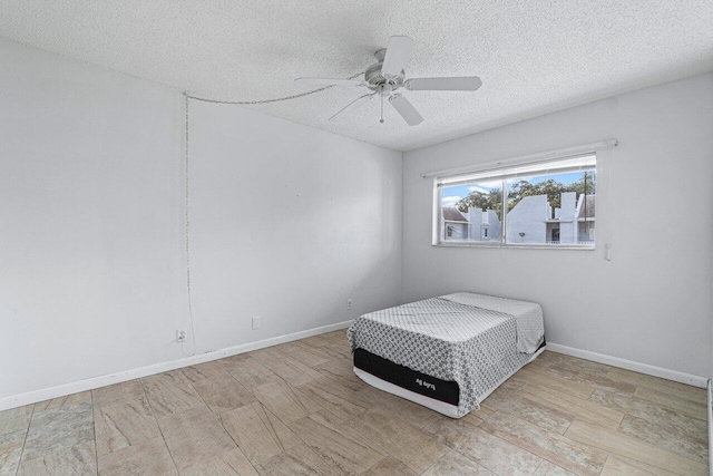 bedroom with a textured ceiling and ceiling fan