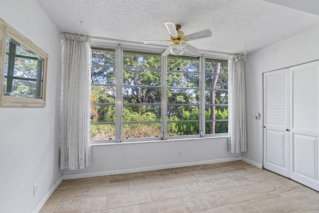 empty room with a textured ceiling and ceiling fan