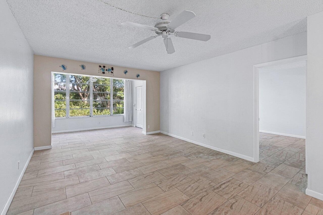 unfurnished room with ceiling fan and a textured ceiling