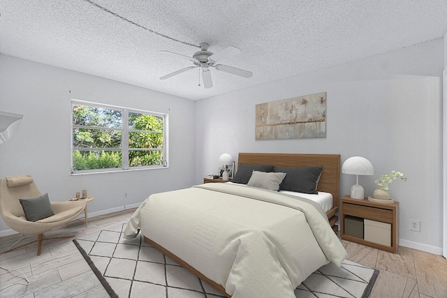 bedroom featuring a textured ceiling, light wood-type flooring, and ceiling fan