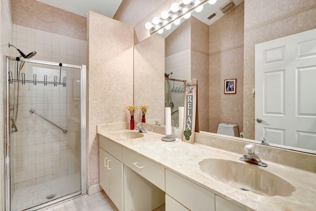 bathroom featuring tile patterned flooring, vanity, toilet, and a shower with shower door