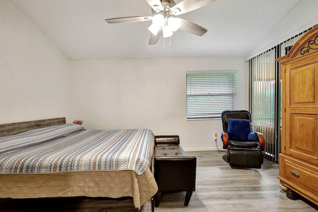 bedroom featuring a textured ceiling, ceiling fan, light hardwood / wood-style flooring, and lofted ceiling