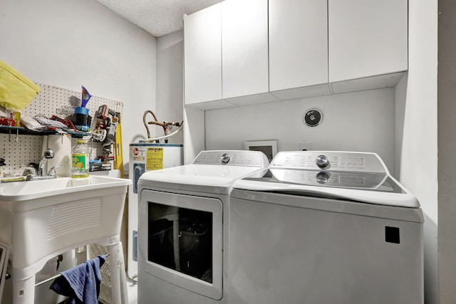 washroom with cabinets, sink, and washing machine and clothes dryer