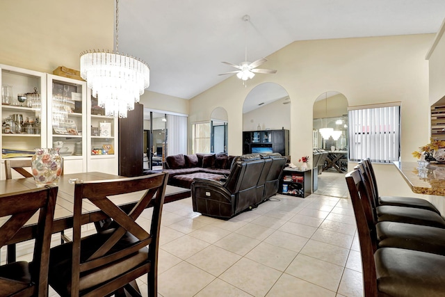 living room featuring ceiling fan with notable chandelier, light tile patterned flooring, and lofted ceiling