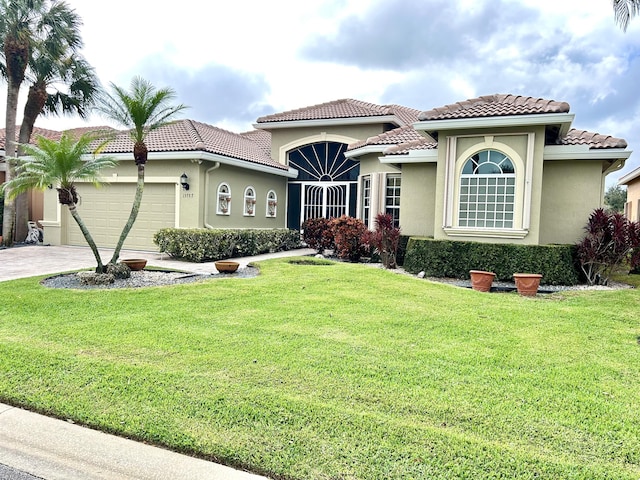 mediterranean / spanish house with a garage and a front yard