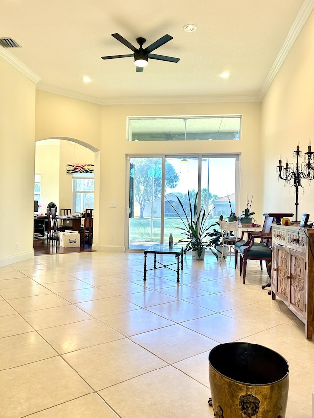 living room featuring ceiling fan, a healthy amount of sunlight, light tile patterned floors, and ornamental molding