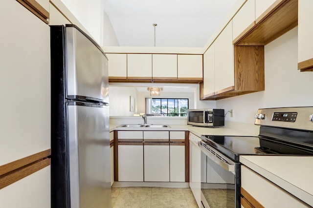 kitchen with sink, light tile patterned floors, stainless steel appliances, and white cabinets