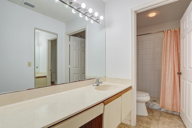 bathroom with a shower with curtain, vanity, tile patterned flooring, and toilet