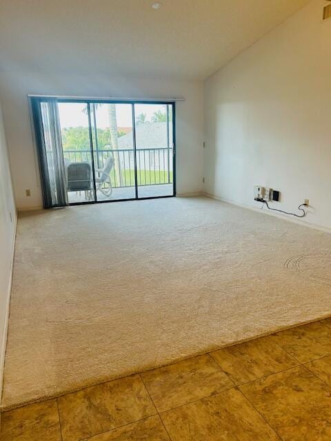 carpeted empty room with vaulted ceiling