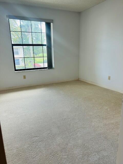 carpeted spare room featuring a textured ceiling