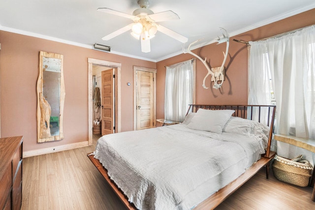 bedroom with multiple windows, hardwood / wood-style flooring, ceiling fan, and crown molding