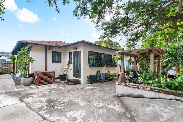 back of property with a pergola and a patio area