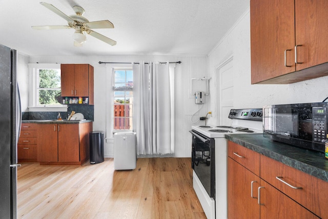 kitchen featuring white electric range oven, ornamental molding, ceiling fan, light hardwood / wood-style flooring, and stainless steel fridge