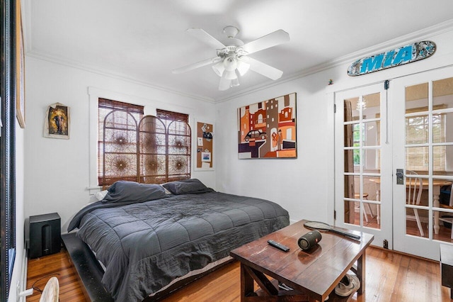 bedroom with crown molding, hardwood / wood-style flooring, multiple windows, and ceiling fan