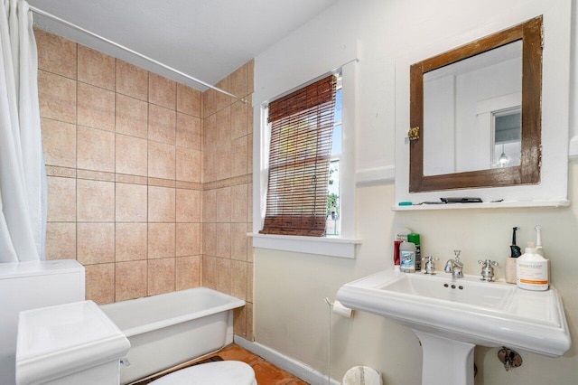 full bathroom with shower / tub combo with curtain, toilet, and sink