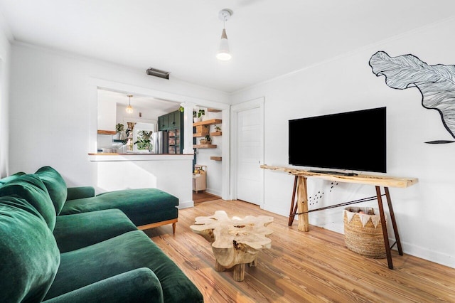 living room with hardwood / wood-style flooring and crown molding