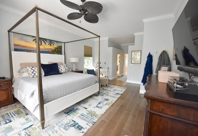 bedroom featuring ceiling fan, crown molding, and hardwood / wood-style floors