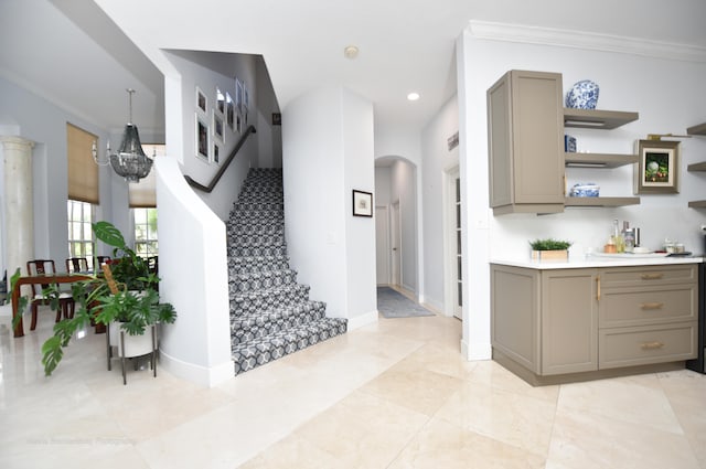 kitchen featuring gray cabinets, ornamental molding, a chandelier, and light tile patterned floors