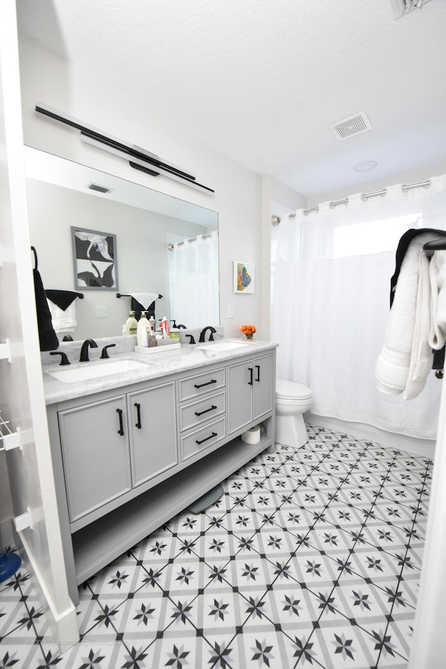 bathroom with vanity, a shower with shower curtain, toilet, and plenty of natural light