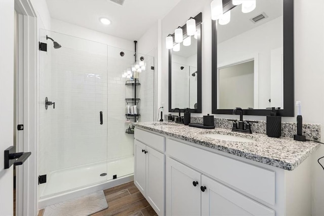 bathroom featuring a shower with door, vanity, and hardwood / wood-style floors