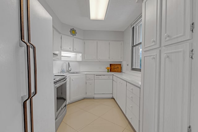 kitchen with sink, refrigerator, electric stove, white dishwasher, and white cabinetry