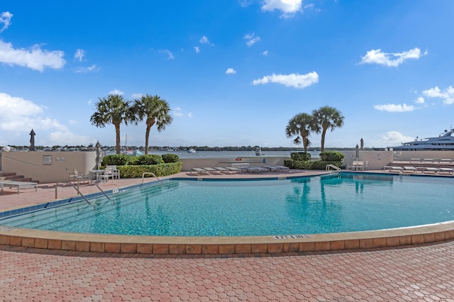 view of pool with a patio and a water view