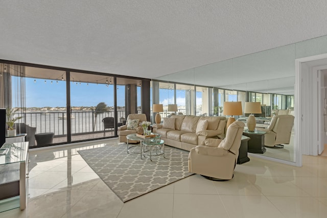 living room featuring a textured ceiling, light tile patterned floors, and a wall of windows