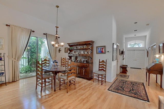 dining room featuring plenty of natural light, a notable chandelier, and light hardwood / wood-style flooring