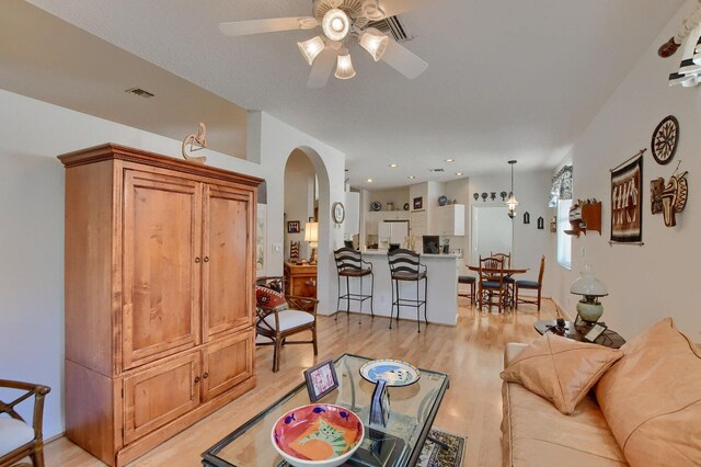 living room with light hardwood / wood-style floors and ceiling fan