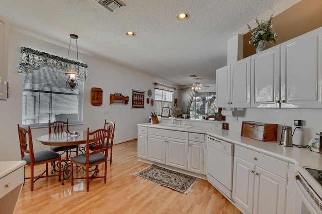 kitchen with pendant lighting, white cabinets, white dishwasher, ceiling fan, and light hardwood / wood-style floors