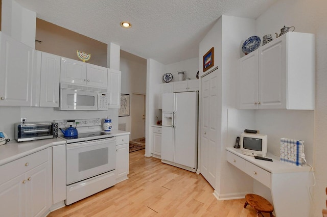 kitchen featuring a textured ceiling, white cabinetry, light hardwood / wood-style flooring, and white appliances