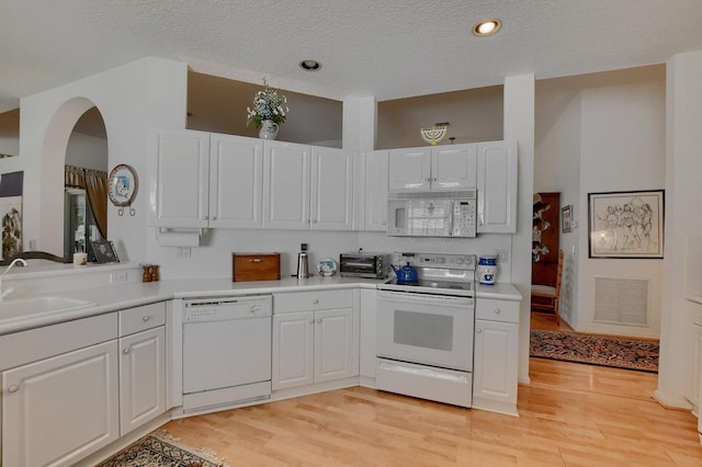 kitchen featuring white cabinetry, light hardwood / wood-style flooring, and white appliances