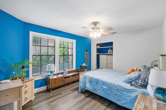 bedroom featuring hardwood / wood-style floors, a textured ceiling, and ceiling fan