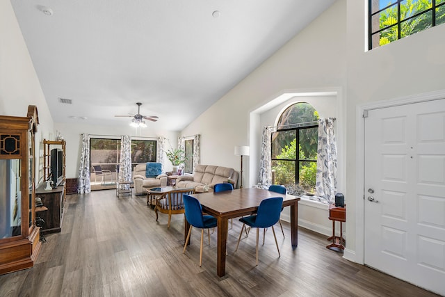 dining space with high vaulted ceiling, dark wood-type flooring, and ceiling fan