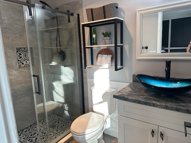 bathroom with vanity, toilet, and an enclosed shower