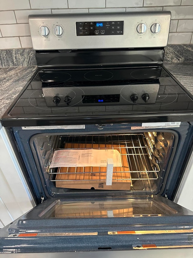 interior details featuring backsplash and stainless steel range with electric stovetop