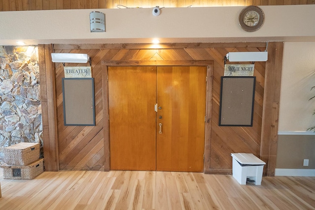 interior space with wood finished floors and wooden walls