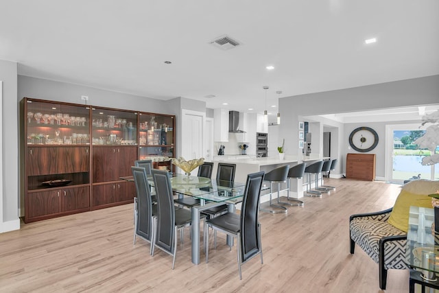 dining space featuring light wood-style flooring, visible vents, baseboards, and recessed lighting