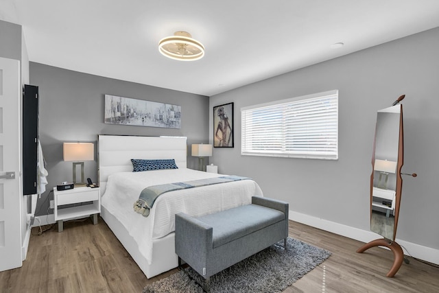 bedroom with baseboards and wood finished floors