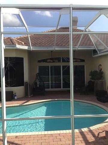 view of pool featuring glass enclosure, ceiling fan, and a patio area