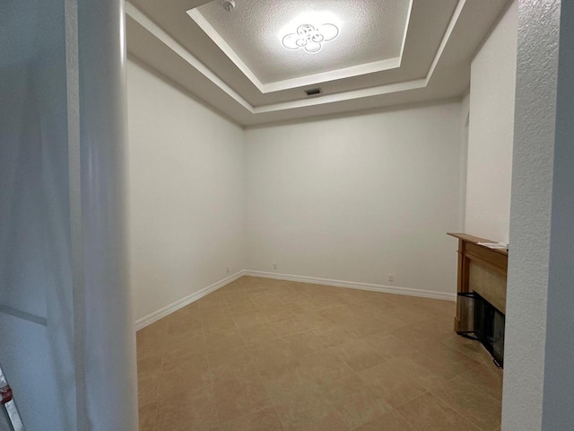 unfurnished room featuring a raised ceiling