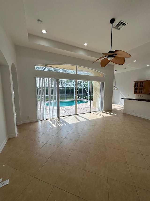 unfurnished living room with light tile patterned floors and ceiling fan