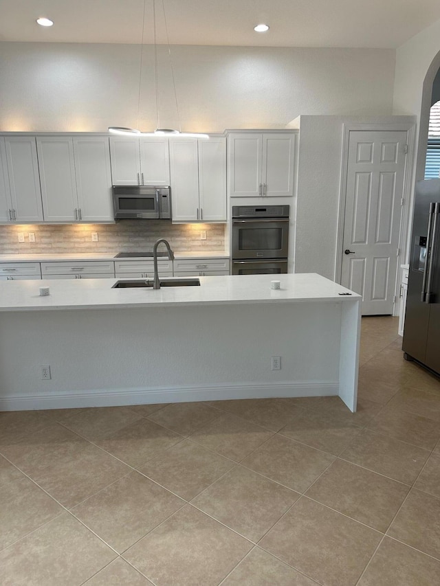 kitchen with white cabinetry, sink, tasteful backsplash, pendant lighting, and appliances with stainless steel finishes