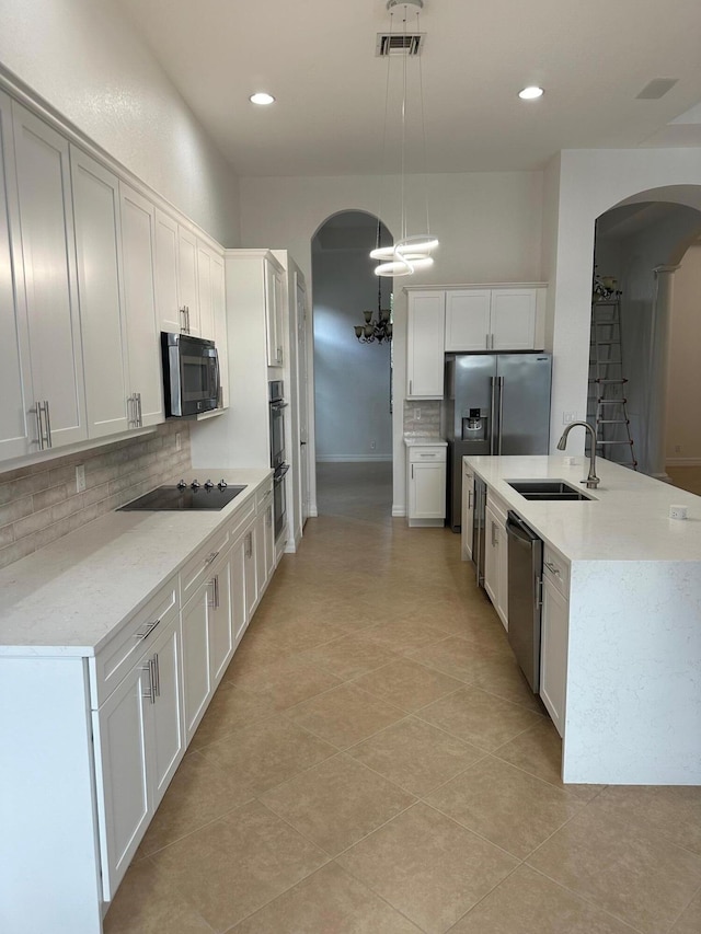 kitchen with white cabinets, stainless steel appliances, and hanging light fixtures