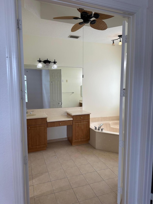 bathroom with tile patterned floors, a tub, ceiling fan, and vanity