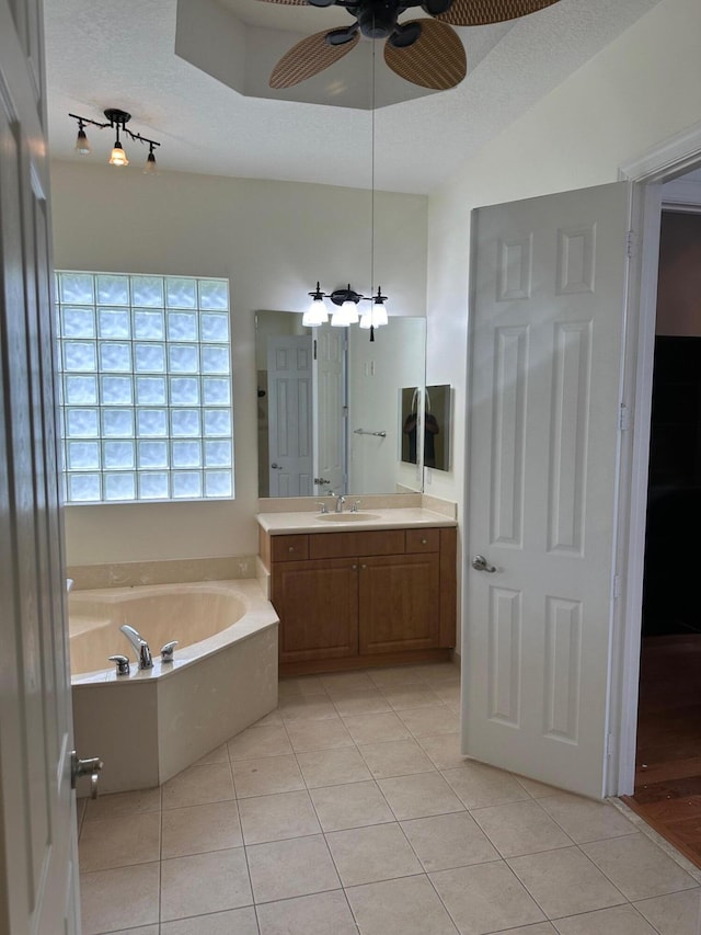 bathroom with tile patterned flooring, a textured ceiling, vanity, and ceiling fan