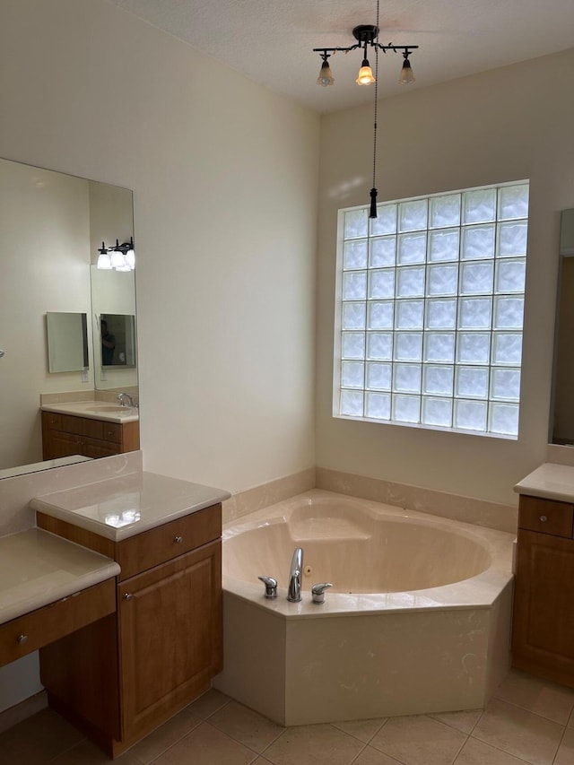 bathroom featuring tile patterned floors, a bathtub, vanity, and a textured ceiling