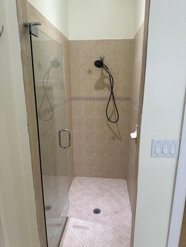 bathroom featuring tile patterned flooring and a shower with shower door