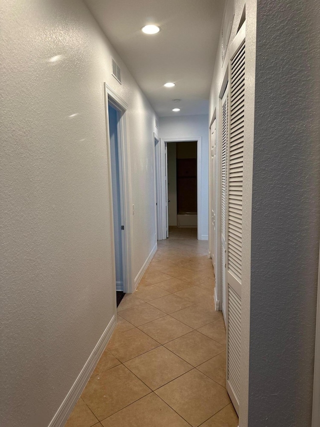 hall with light tile patterned floors