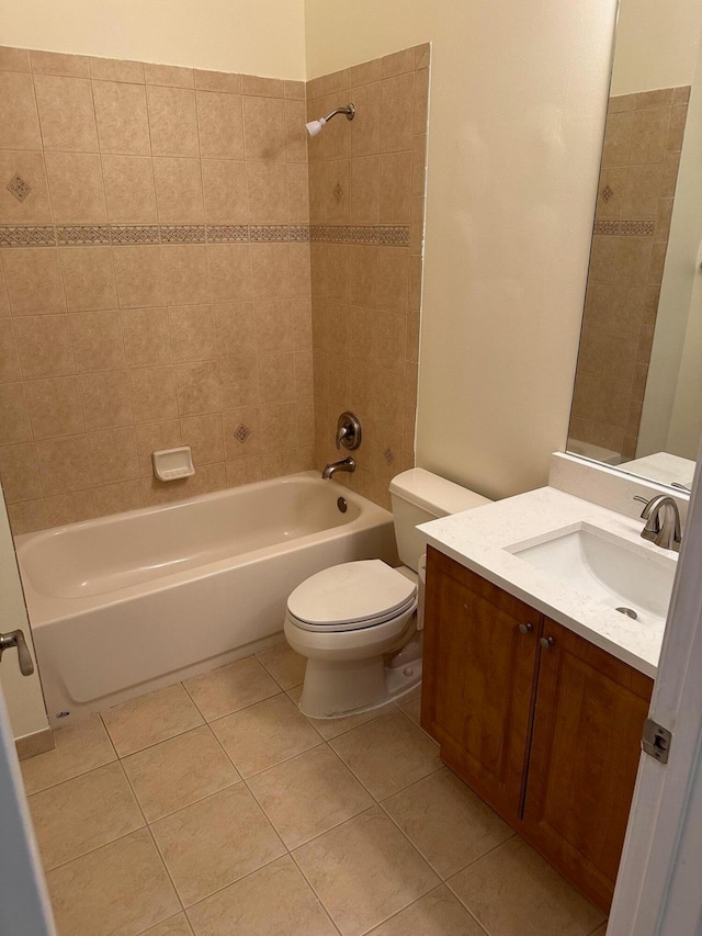 full bathroom featuring tile patterned flooring, vanity, toilet, and tiled shower / bath combo